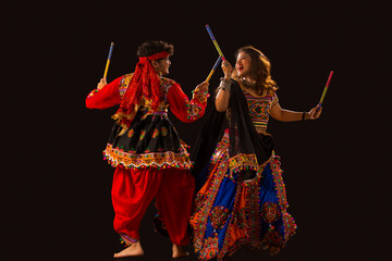 A couple playing dandiya on the event of Navratri